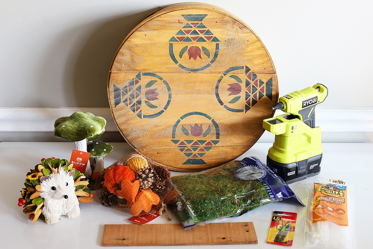 Supplies to make the woodland wreath including woodland animals, mushroom, moss, Ryobi glue gun, glue sticks, saw-tooth hanger kit and small fall decorative items.