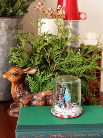 Looking to shake up your holiday decor? Learn how to make these enchanting DIY Waterless Snow Globes using repurposed jars! A quick, easy and inexpensive holiday craft project the kids can help with.