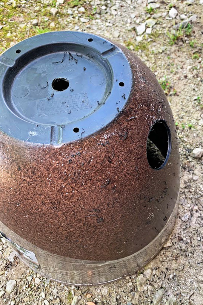 Showing the hole made in the bottom of the planter which will be used to hold the garden hose.