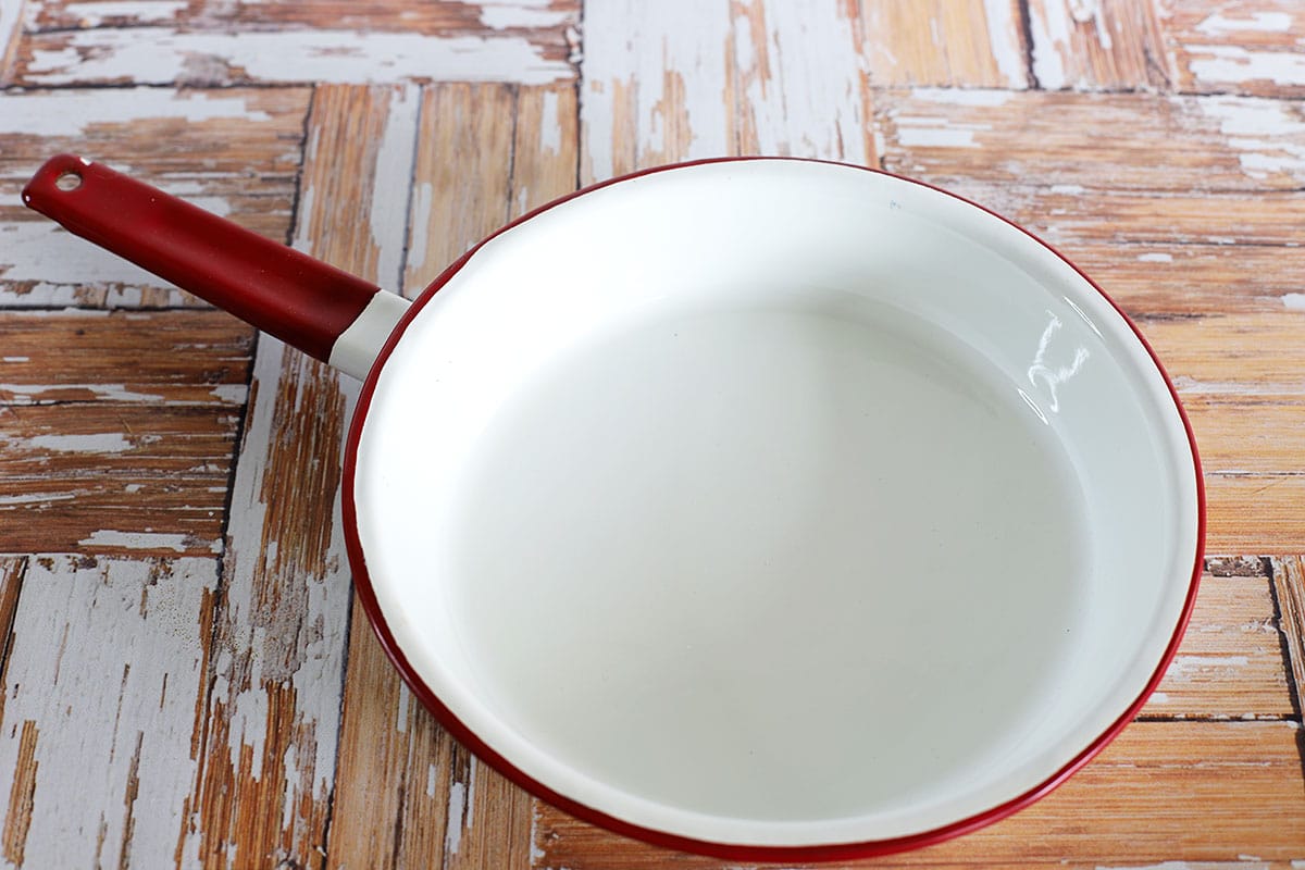 Red and white enamelware frying pan.