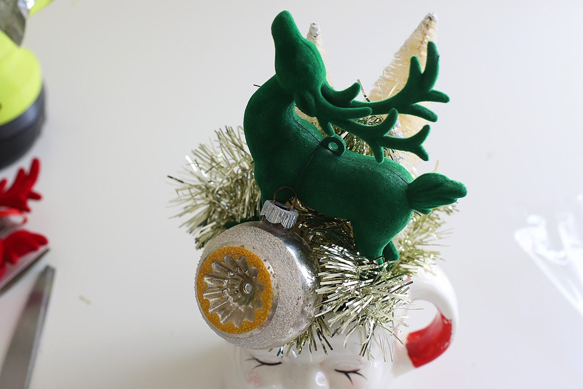 Green flocked reindeer in a vintage Santa mug.