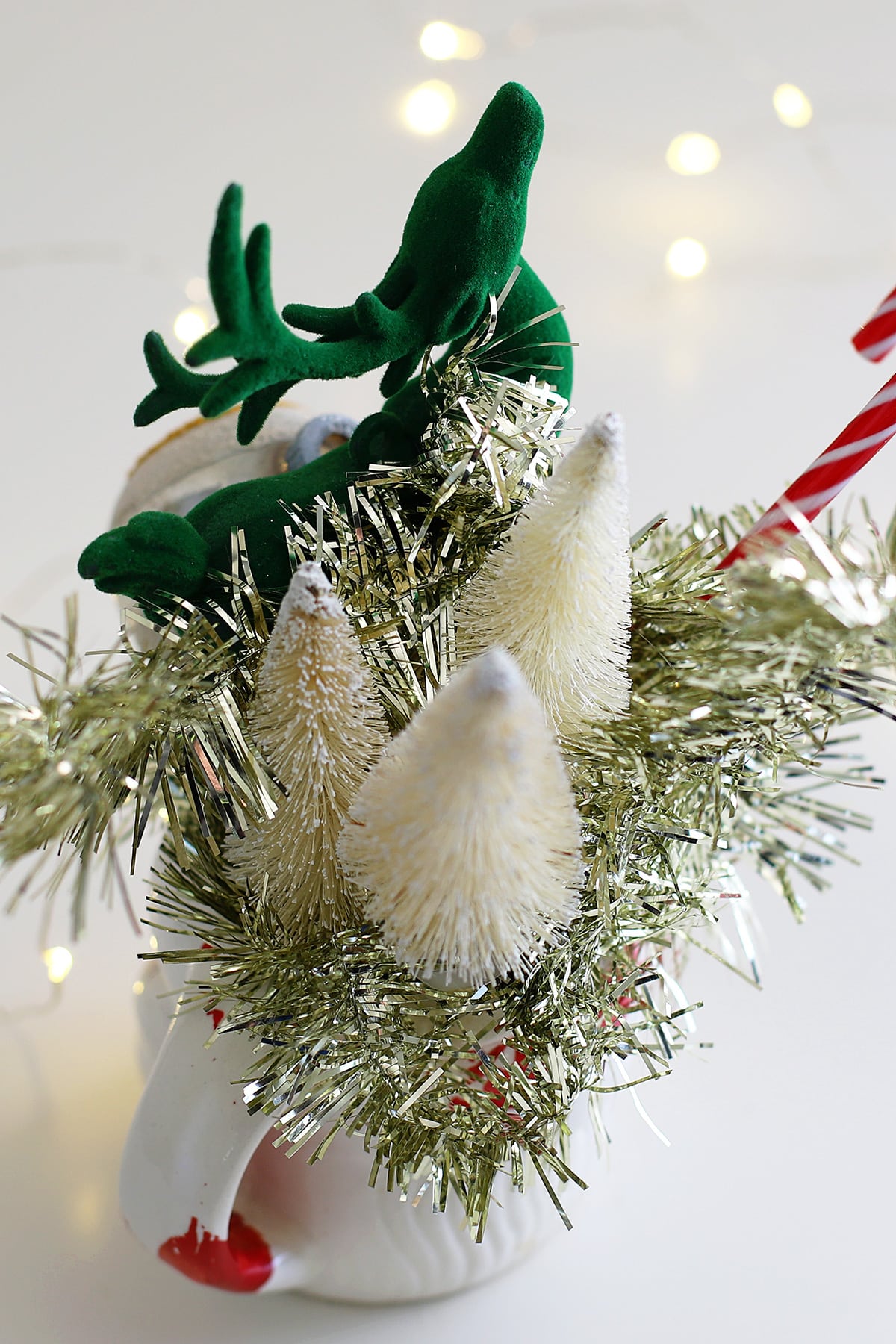 Bottle brush trees and a green reindeer in a vintage Santa mug for retro holiday decor!