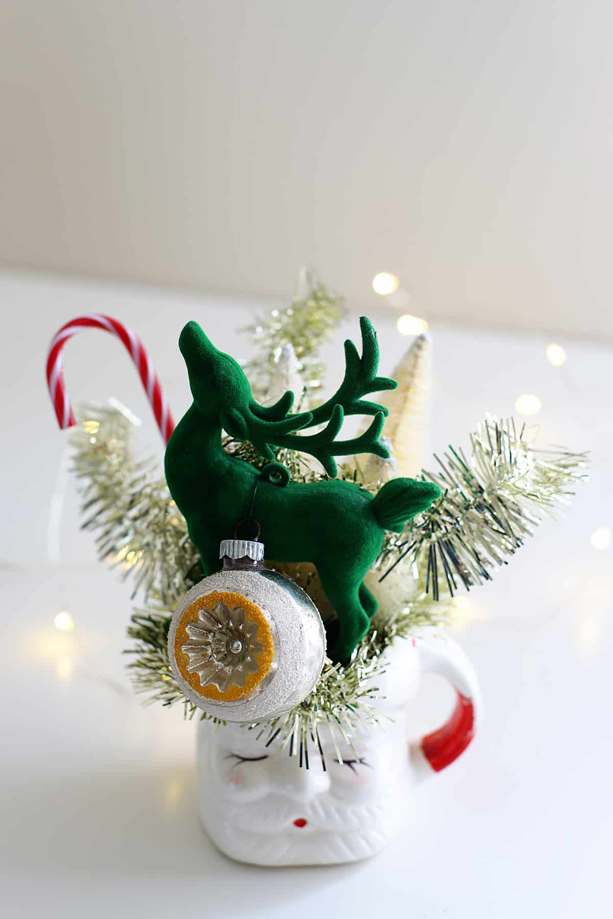 Bottle brush trees and a green reindeer in a vintage Santa mug for retro holiday decor!