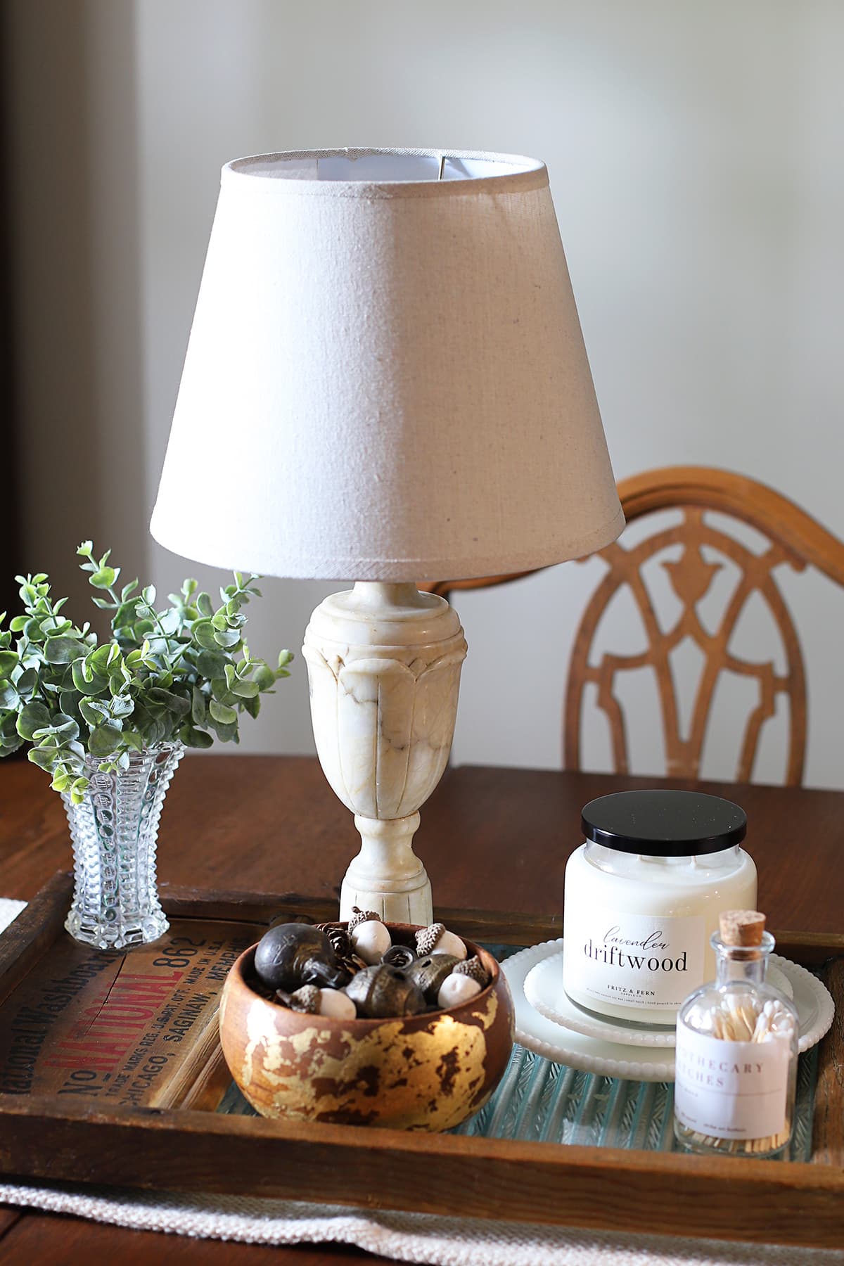 Repurposing a vintage wood and glass washboard into a rustic table centerpiece including a vintage alabaster lamp and upcycled monkeypod bowl.