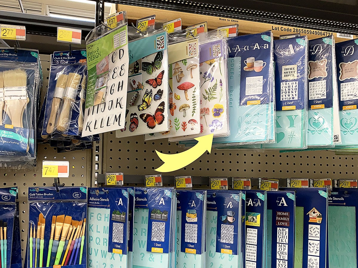 Ponting out rub-on transfers in the Walmart craft supplies aisle.