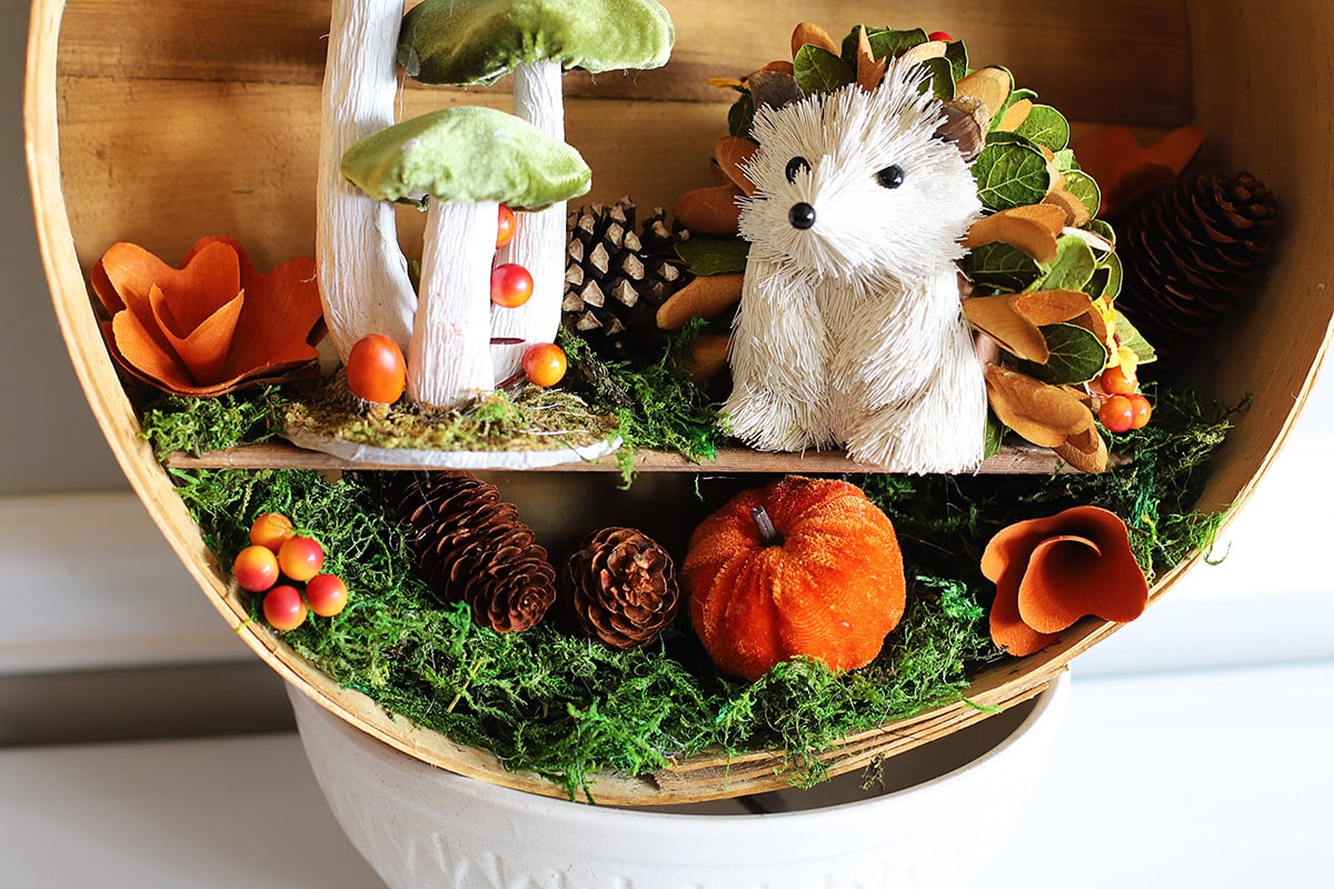 Adding the pumpkins, pinecones and berries to the woodland fall wreath.